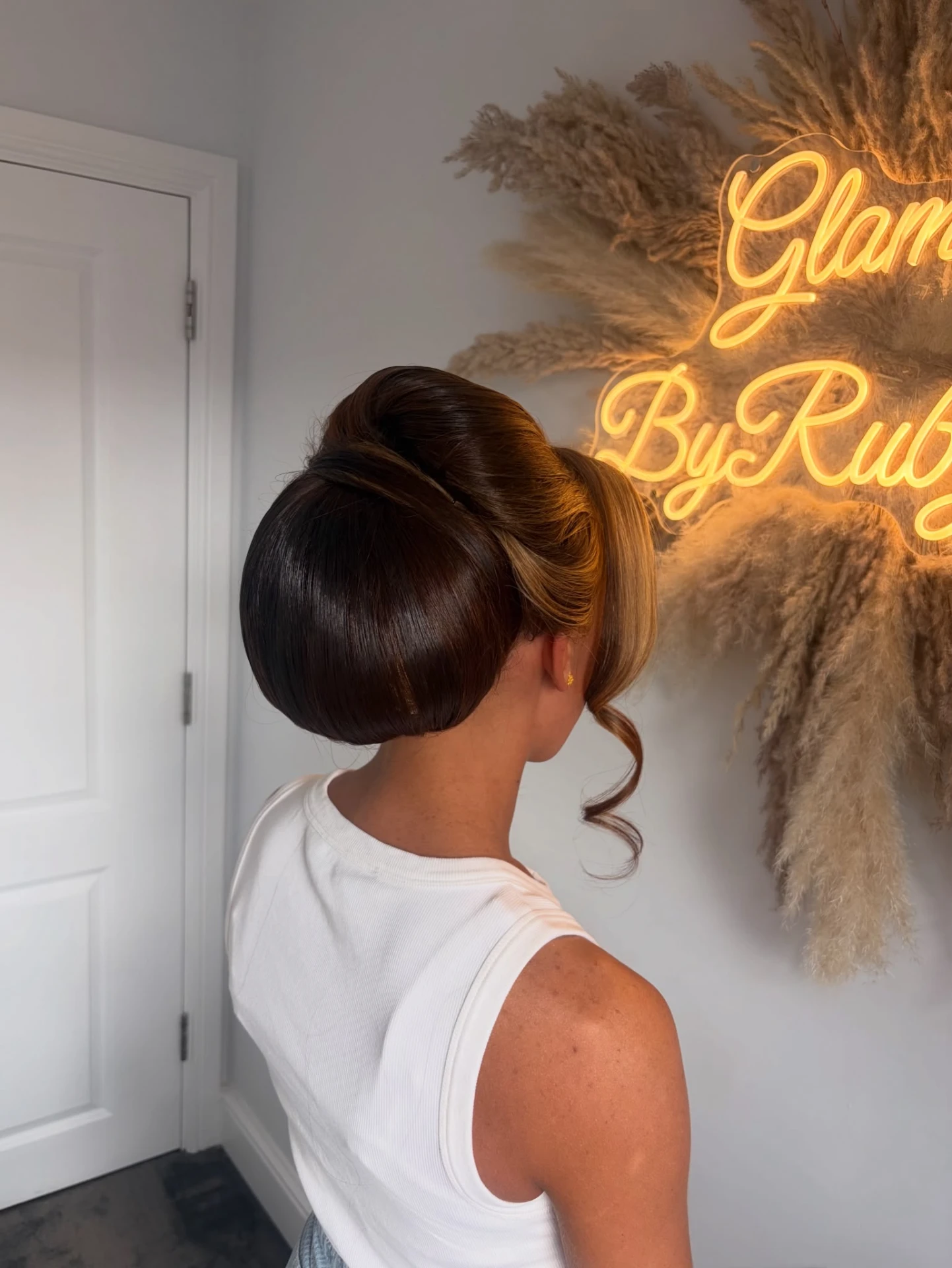 Glossy chignon with soft face-framing curl